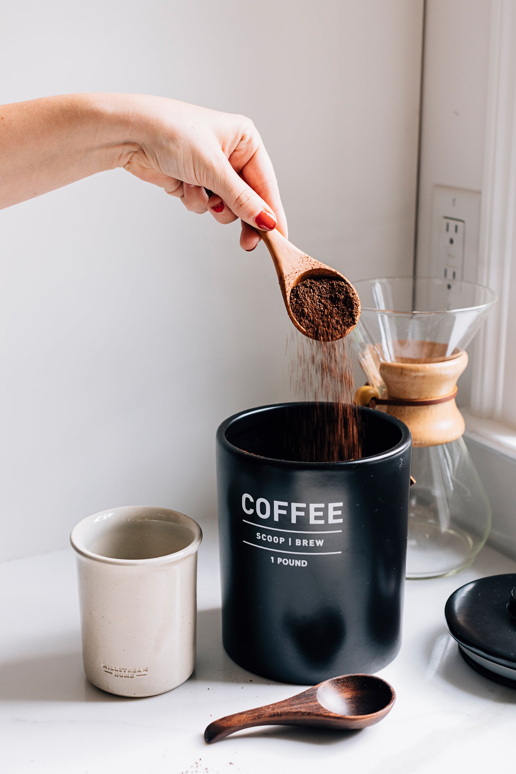 The Coffee Scoop Pouring Coffee Grounds into a Cup